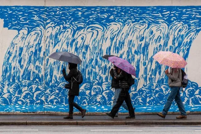 Umbrelă deschisă pe o stradă udă din oraș, în ploaia de toamnă